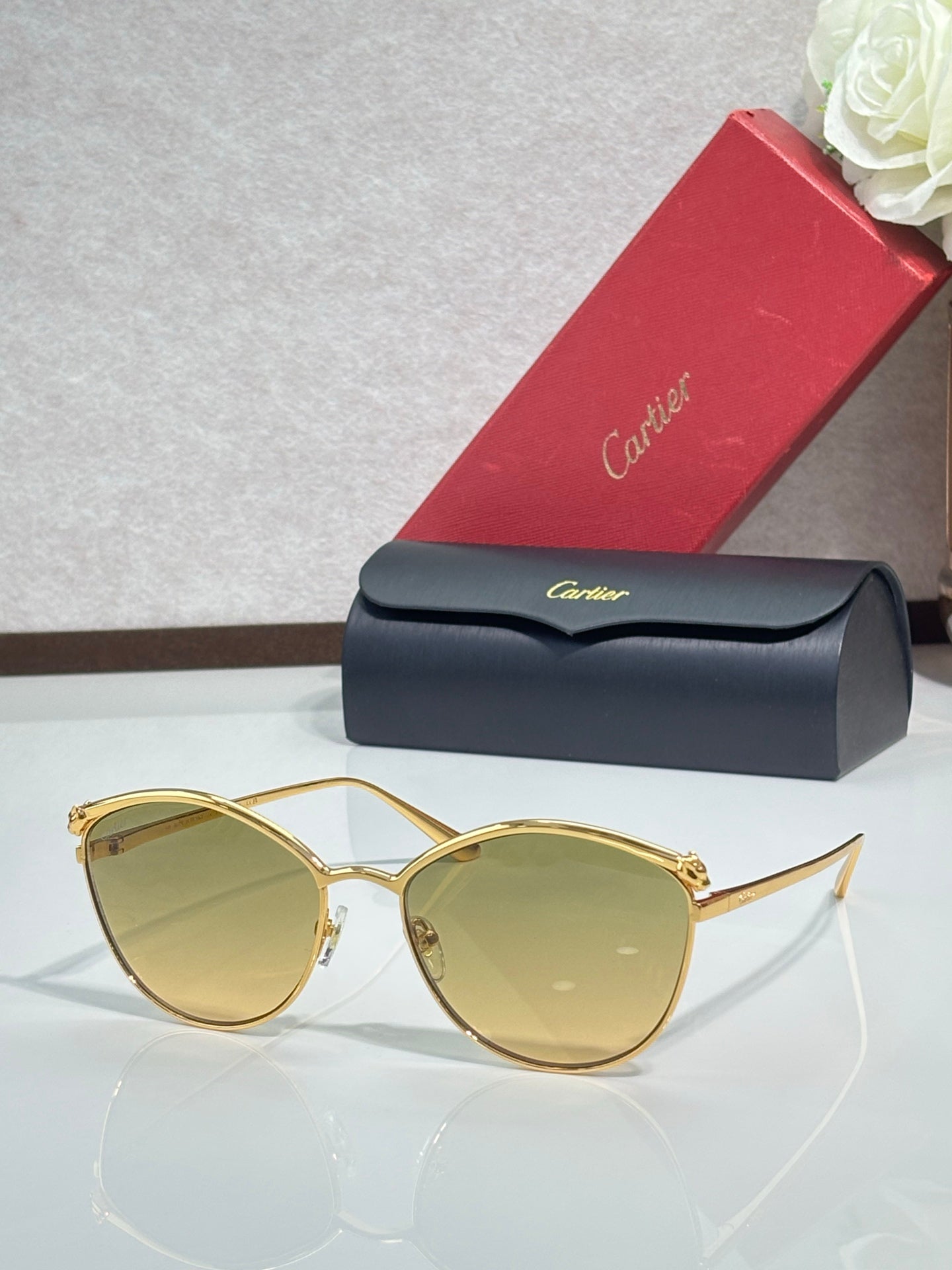 Gold round sunglasses with tinted light amber lenses and slim metal frame, clear bridge detail.