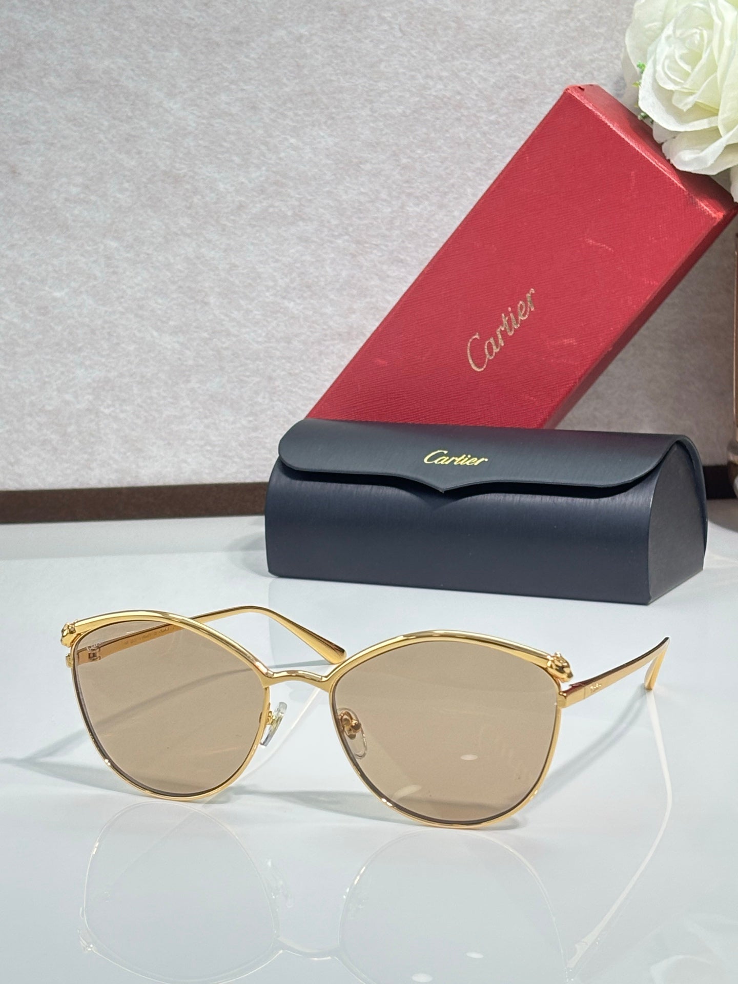 Gold round sunglasses with tinted beige lenses and slim metal frame, clear bridge detail.