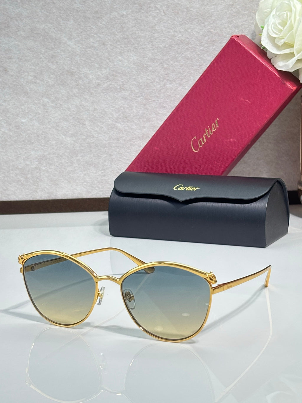 Gold round sunglasses with light blue tinted lenses and slim metal frame, clear bridge detail.