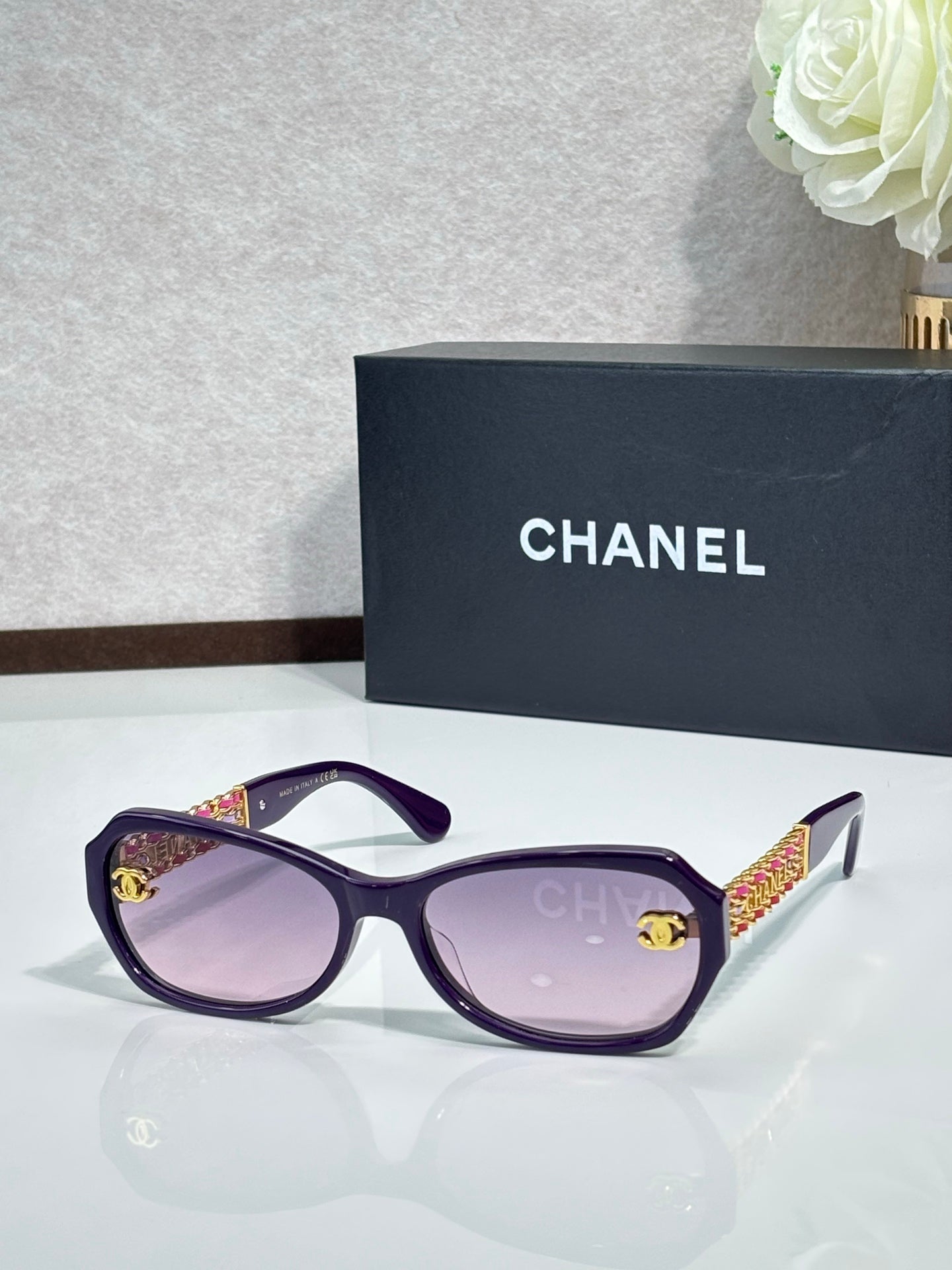 Purple sunglasses with tinted lenses and gold CC detail on temples
