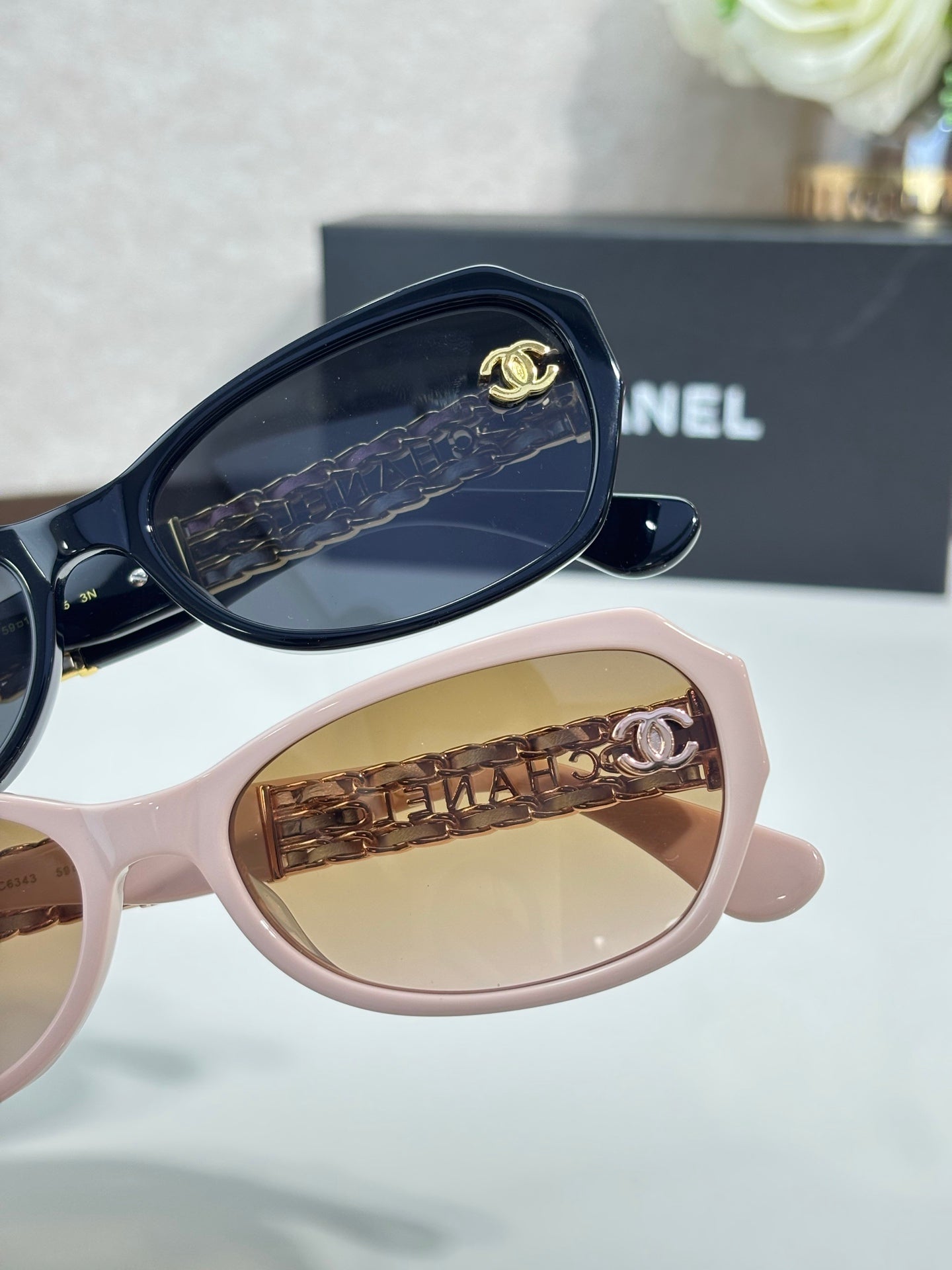 Pink sunglasses close-up with brown lenses and gold CC temple detail