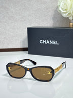 Black sunglasses with gold CC detail and brown-tinted lenses
