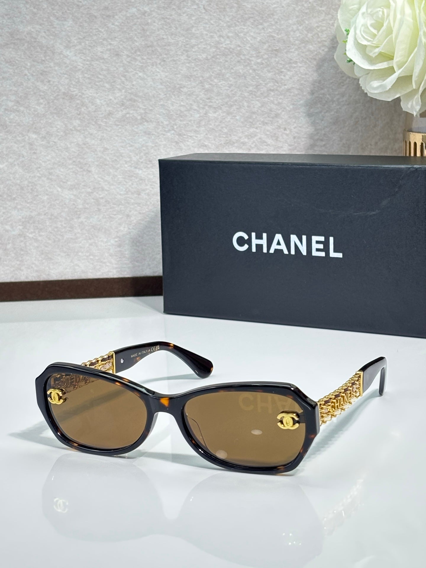 Black sunglasses with gold CC detail and brown-tinted lenses
