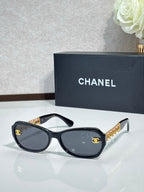 Black sunglasses with dark lenses and gold CC detail on temples