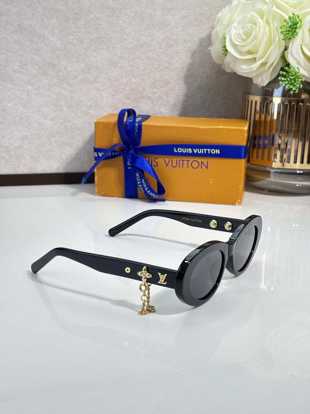 Louis Vuitton black round sunglasses with gold logo studs and dangling charm chain