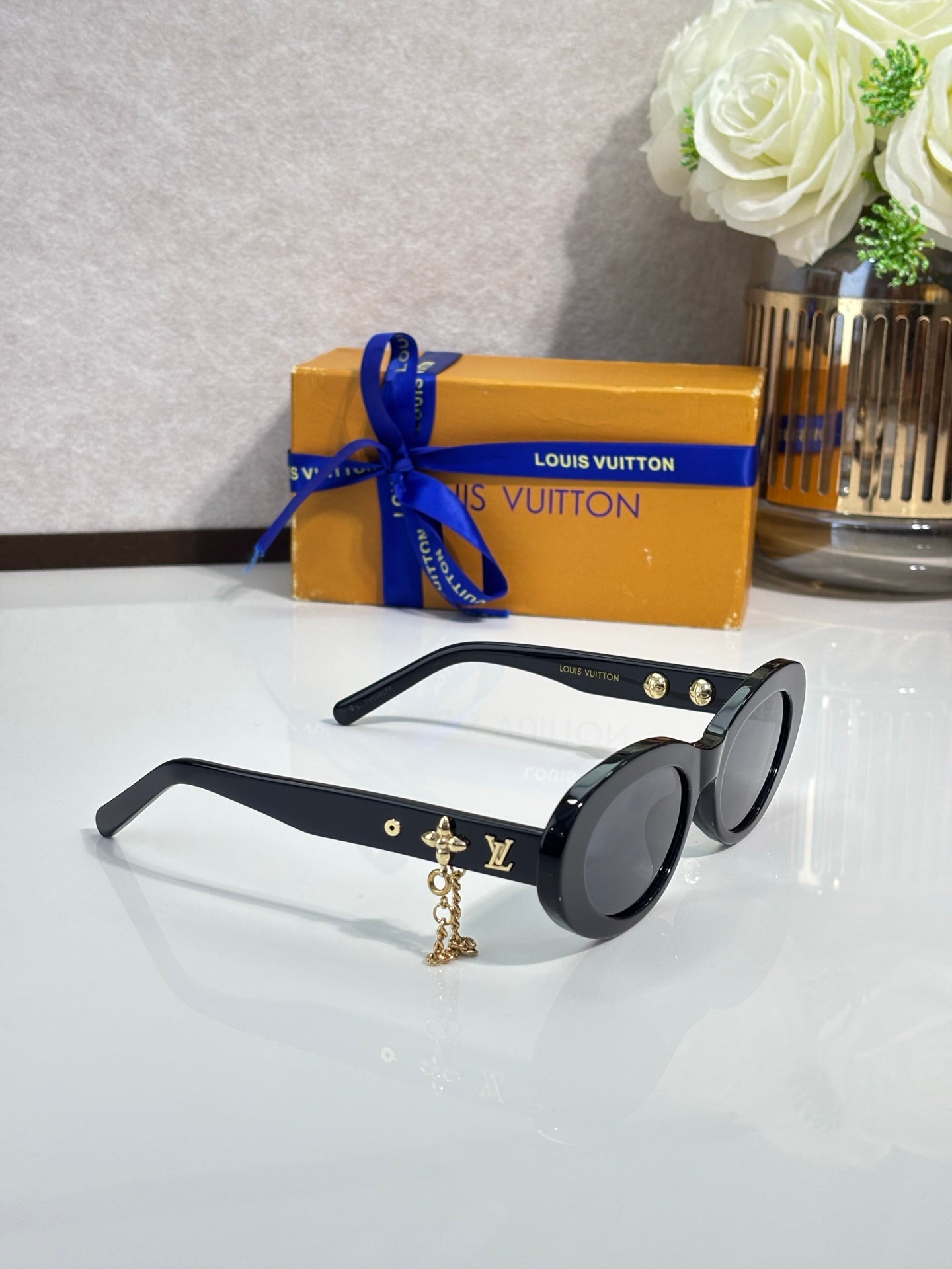 Louis Vuitton black round sunglasses with gold logo studs and dangling charm chain