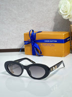 Louis Vuitton black round sunglasses with gold logo accents and dark tinted lenses