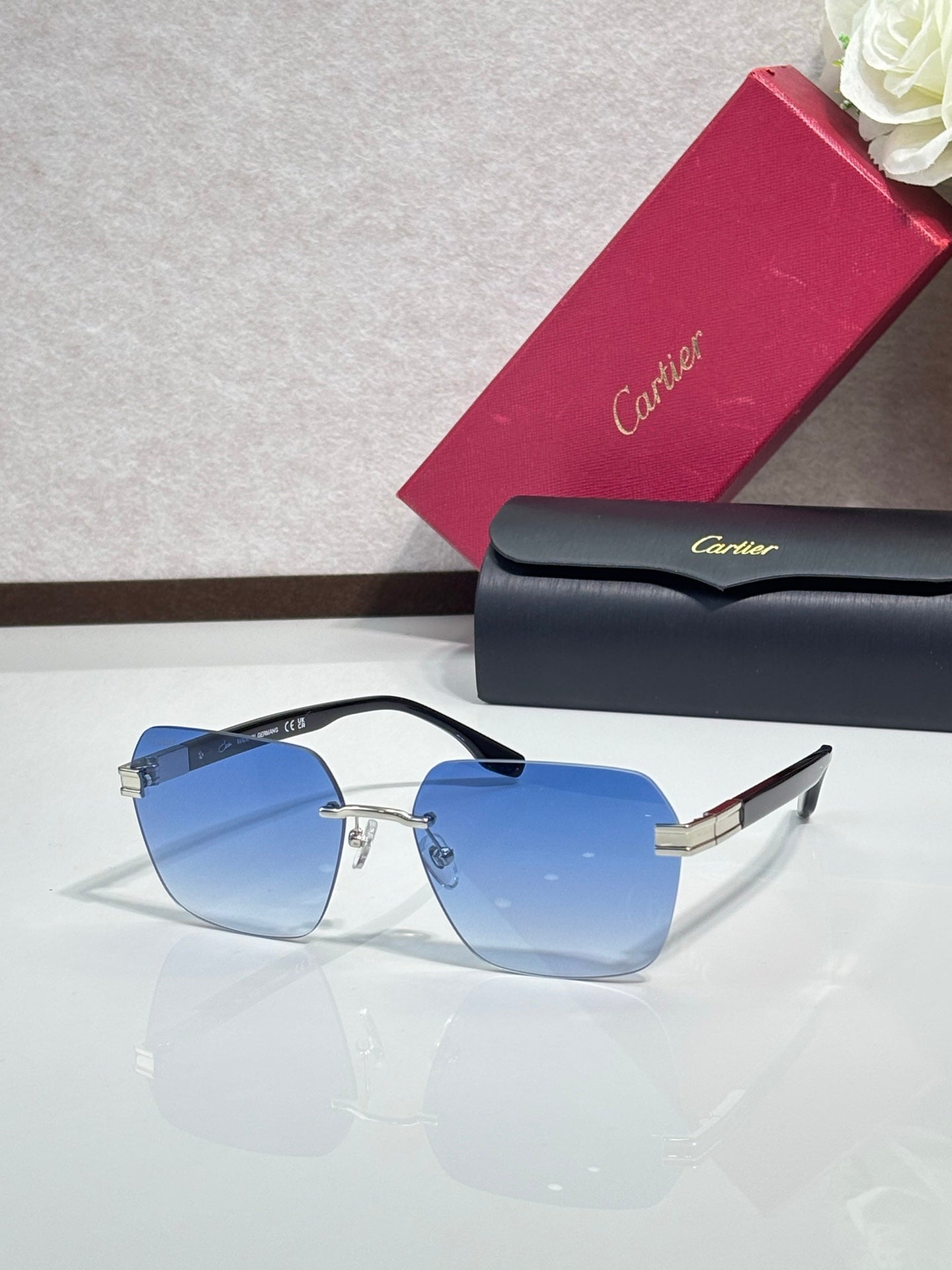 Cartier sunglasses with light blue tinted lenses and gold-tone metal frame, black temples