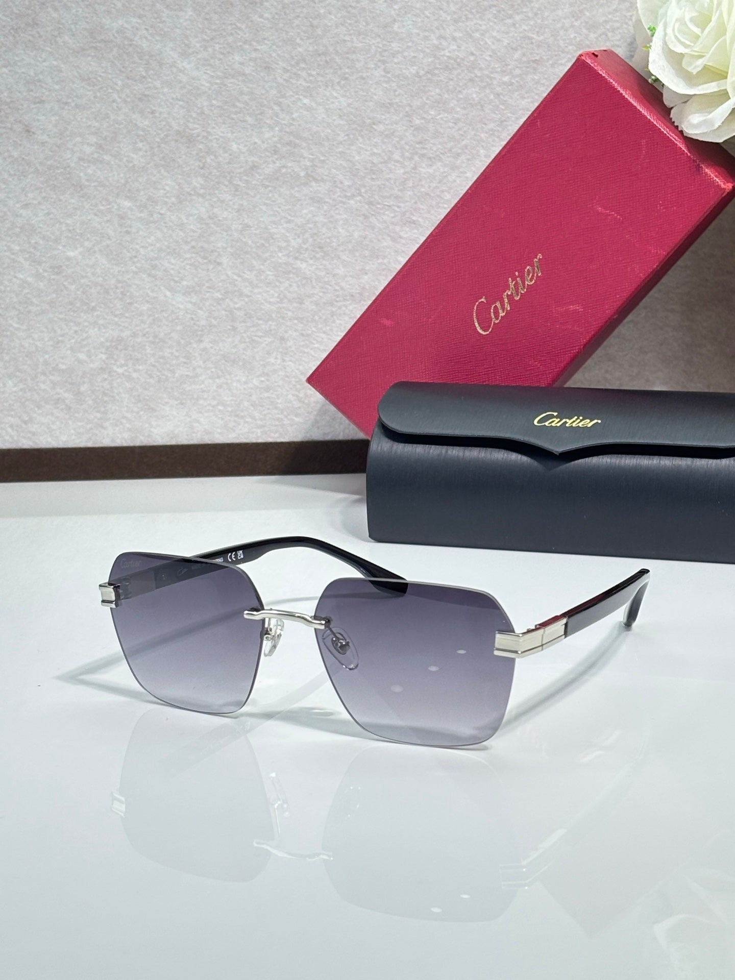 Cartier sunglasses with purple-tinted lenses and gold-tone hinge details, angular black frame