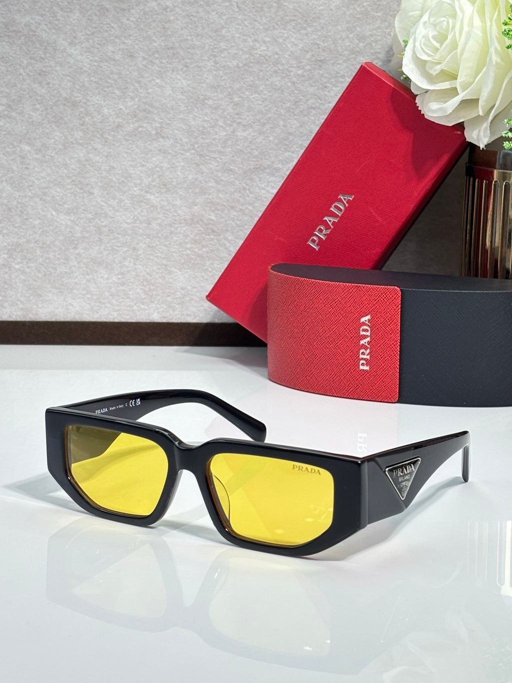Prada sunglasses with black frames and yellow-tinted lenses