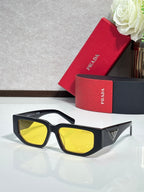 Prada sunglasses with black frames and yellow-tinted lenses