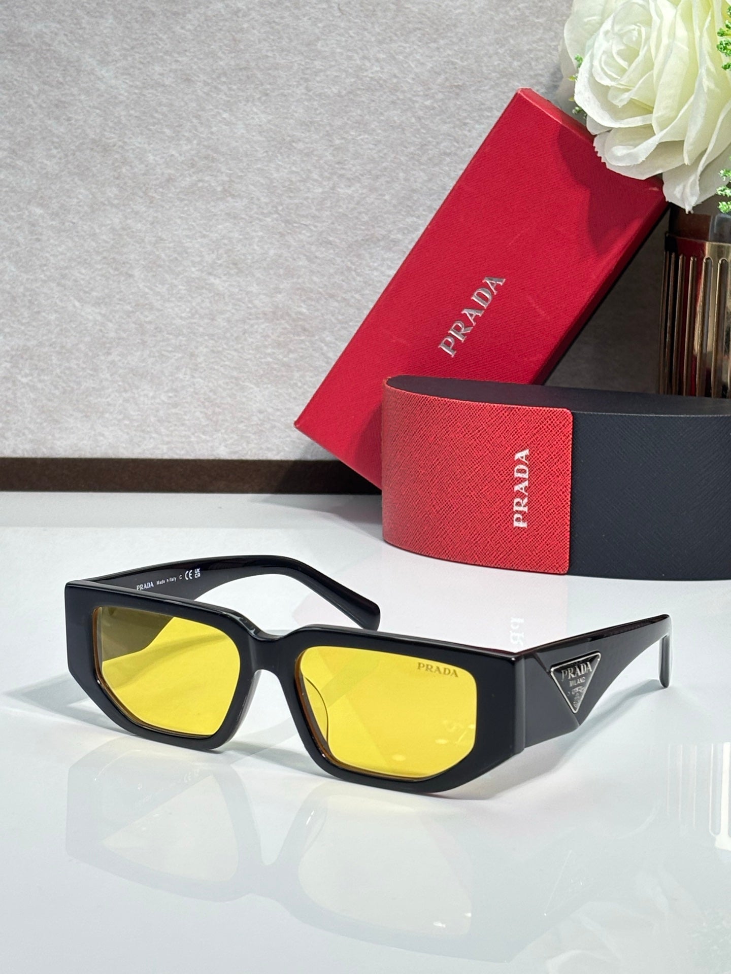 Prada sunglasses with black frames and yellow-tinted lenses
