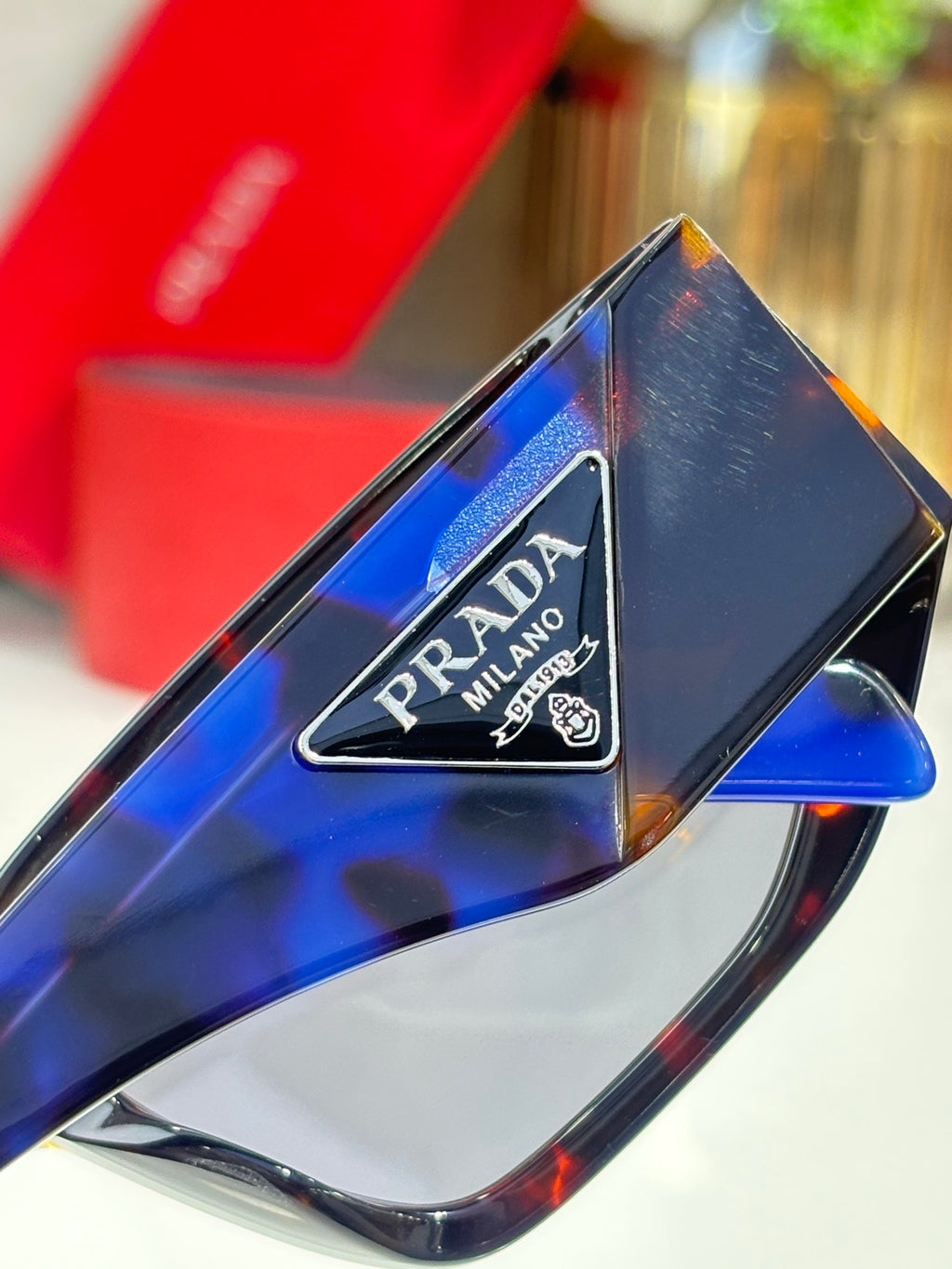 Prada Milano logo on dark sunglasses temple, glossy frame