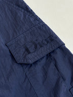 Navy cargo shorts with stitched logo patch on pocket