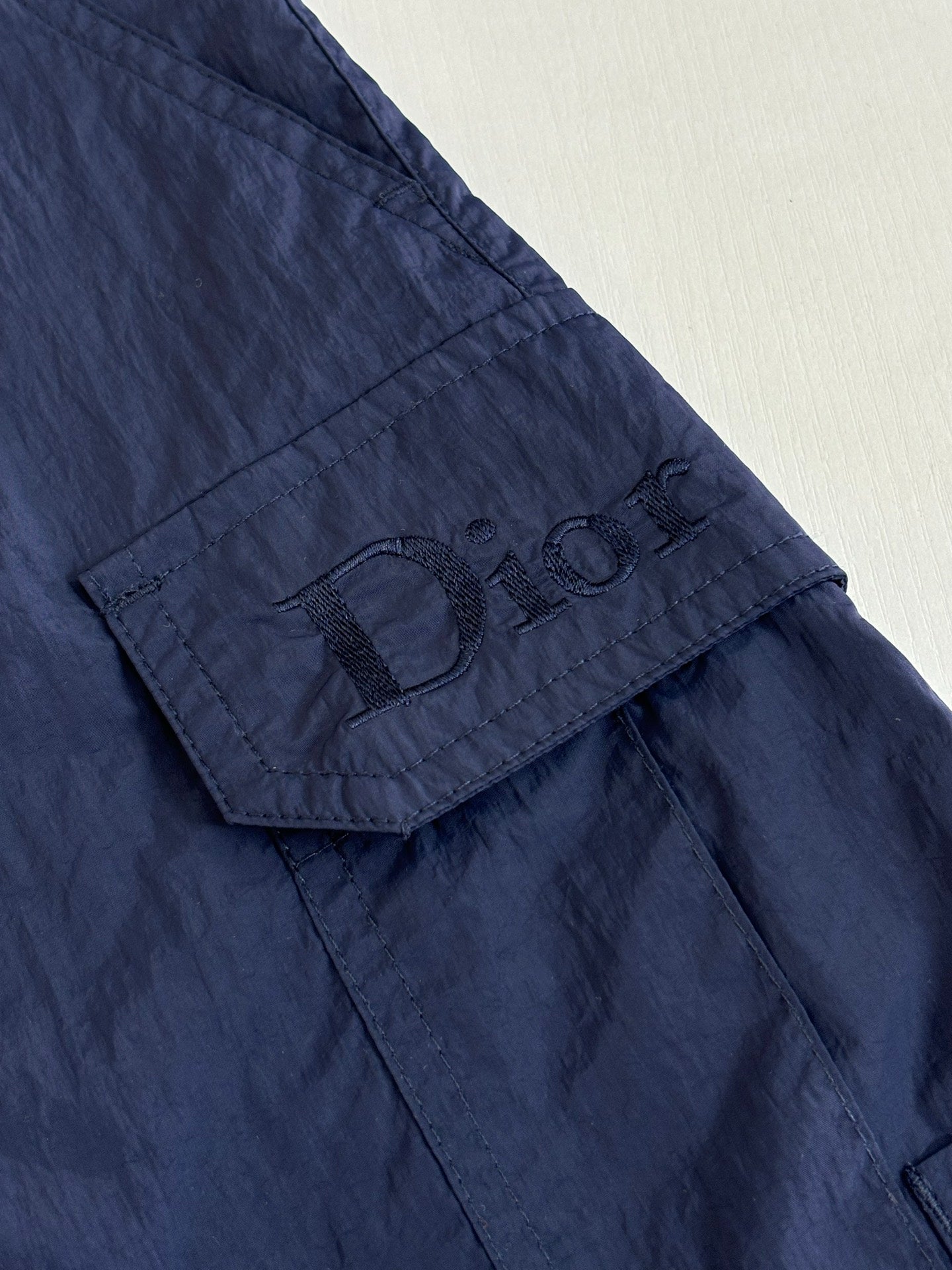 Navy cargo shorts with stitched logo patch on pocket