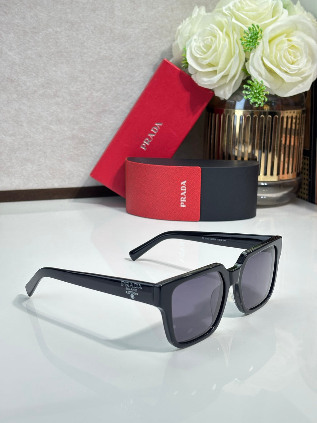 Prada sunglasses with black frame and dark tinted lenses, side profile