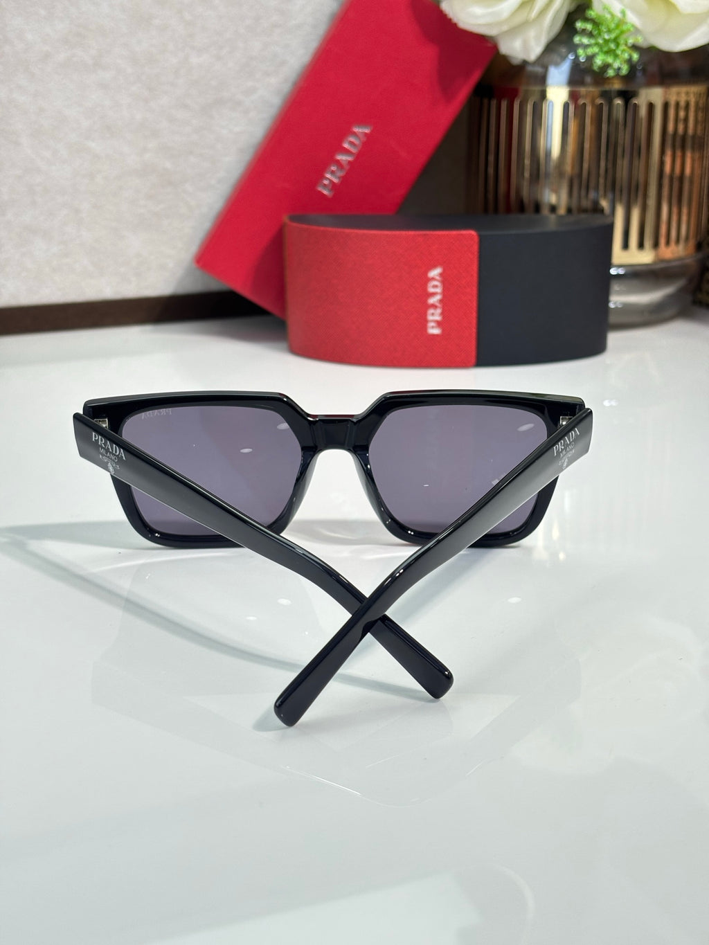 Prada sunglasses with black cat-eye frame and dark tinted lenses