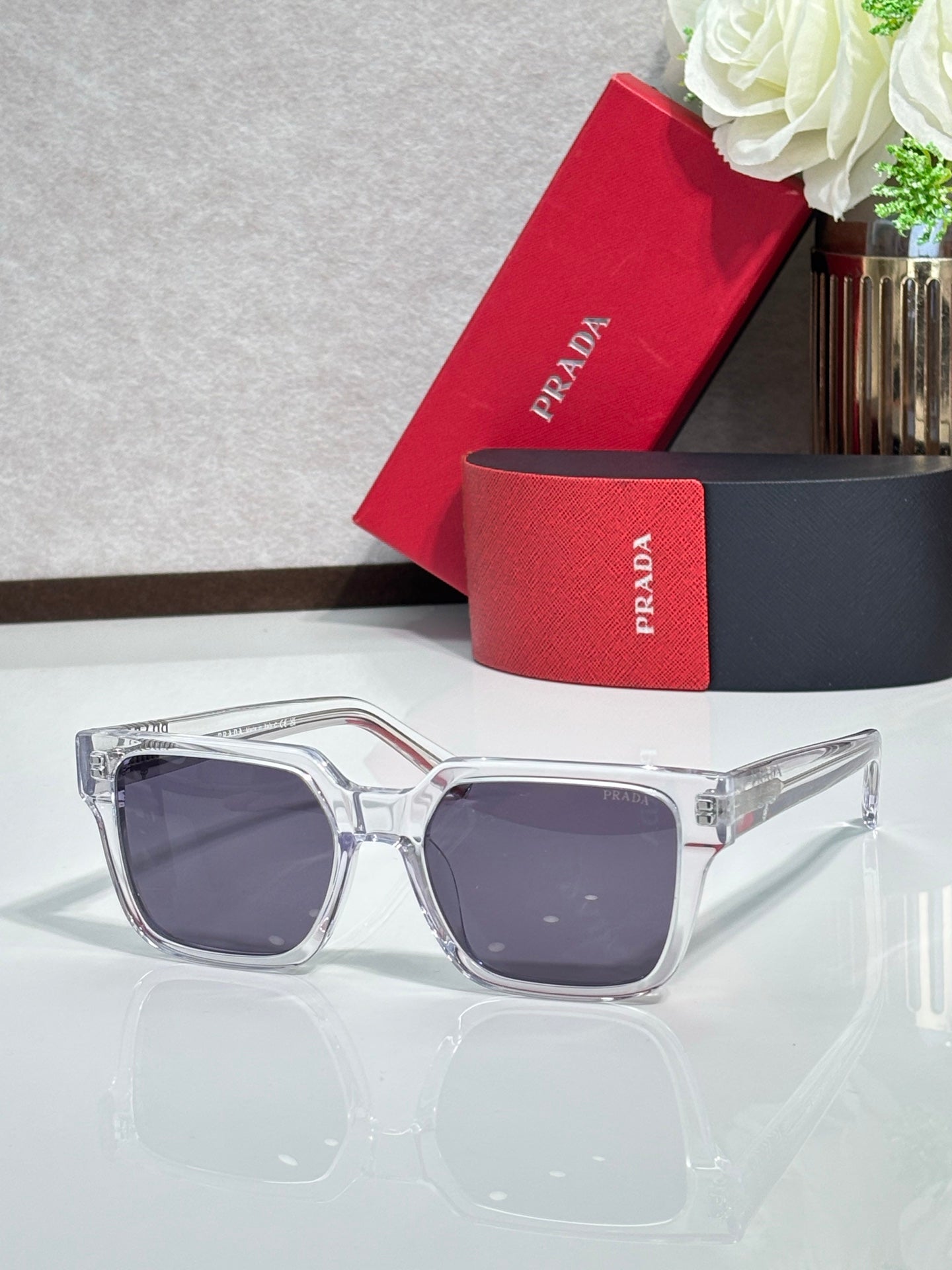 Prada sunglasses with clear frame and dark purple-tinted lenses