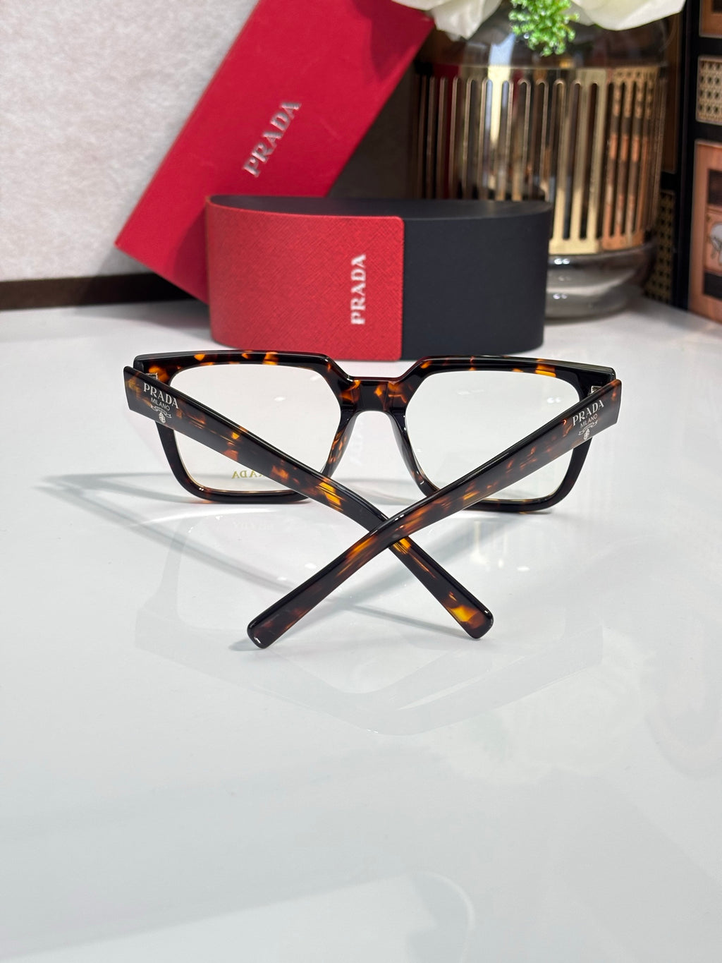 Tortoise rectangular eyeglasses with clear lenses and logo on temple, angled