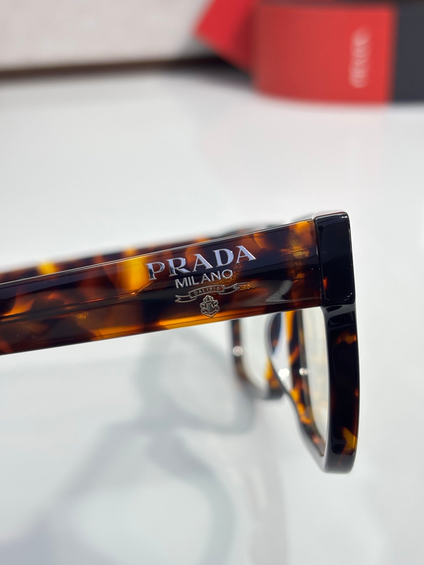 Tortoise eyeglasses with PRADA Milano text on top bar and clear lenses