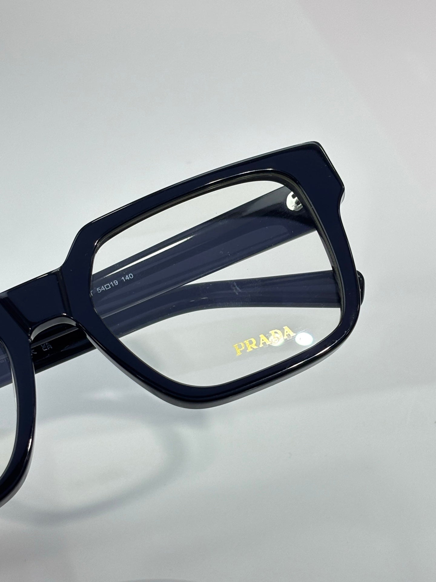Navy square eyeglasses with PRADA logo on arm and clear lenses