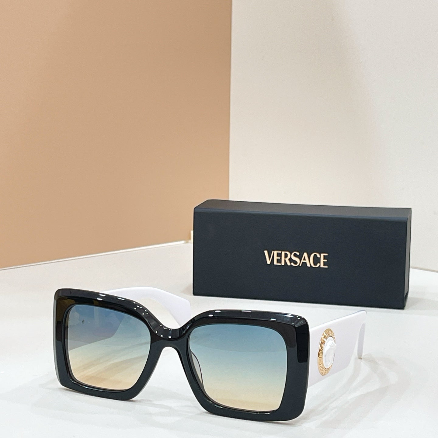 Versace glasses, black square frames with gold logo and blue-tinted lenses