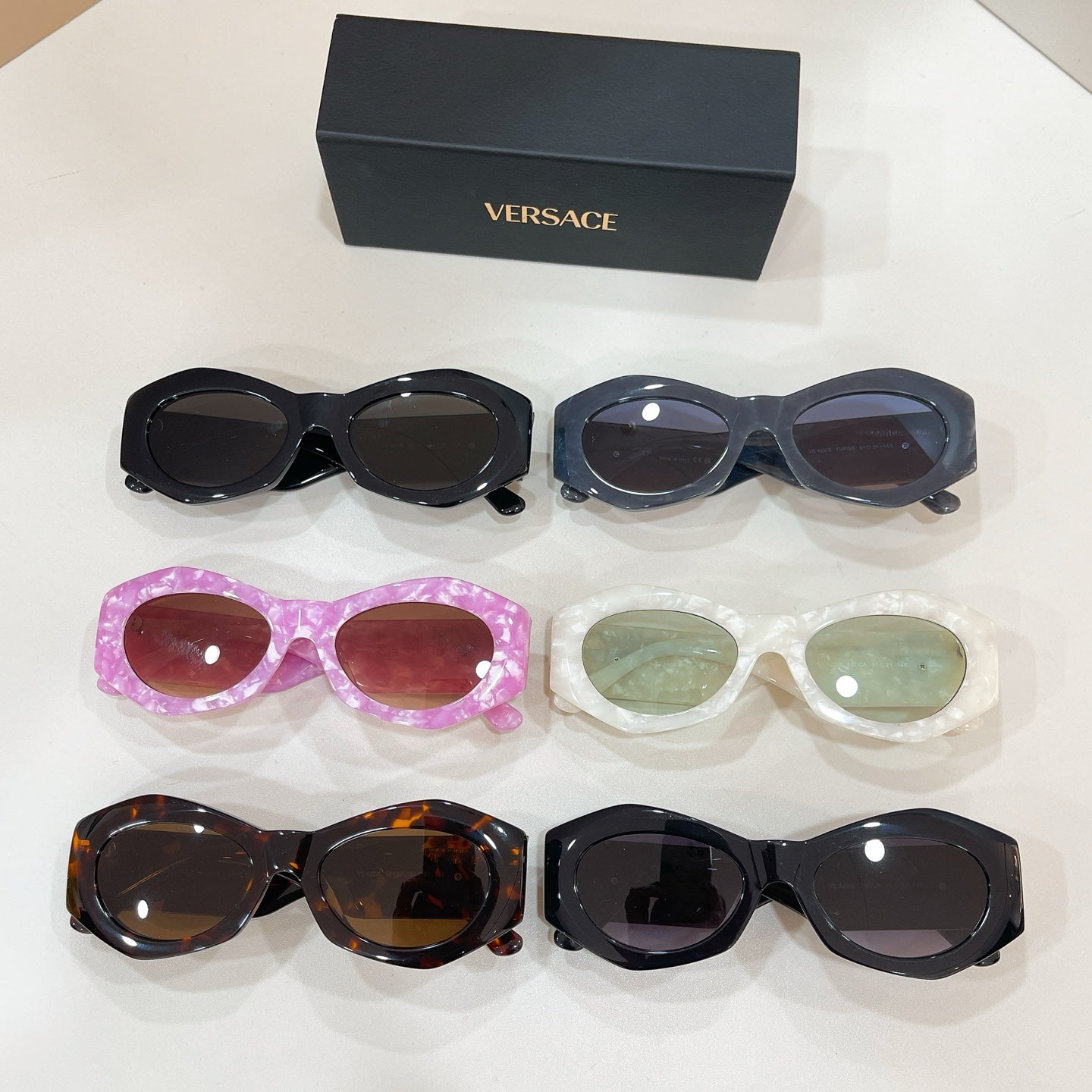 Multi-pack of oval sunglasses in black, pink, white, and tortoiseshell with tinted lenses