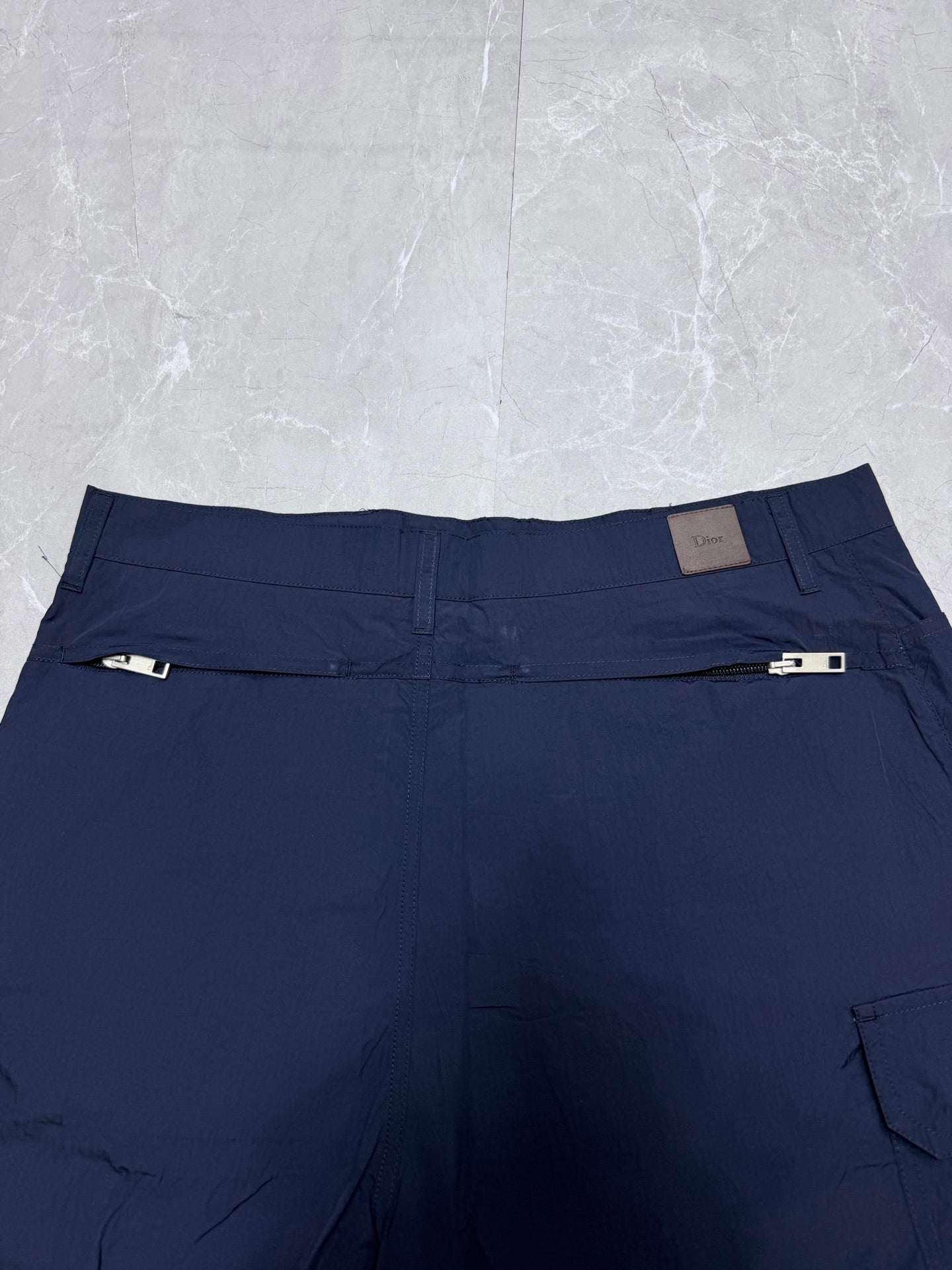 Navy Dior shorts back view with belt loops and small logo label