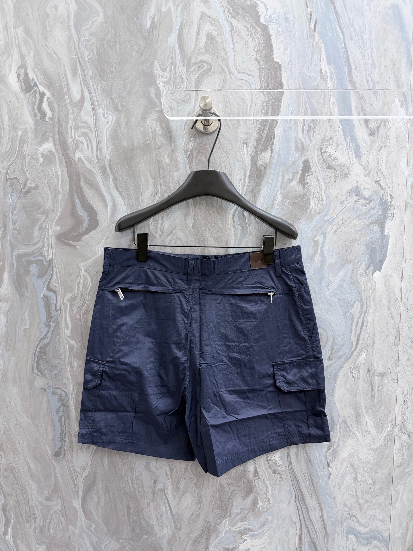 Navy Dior shorts on hanger, front with cargo pockets