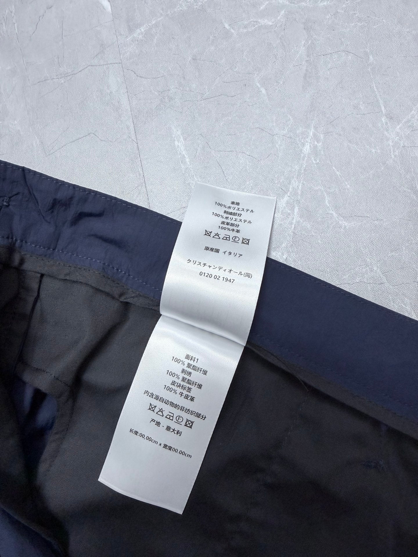 Dior navy shorts waist with hanging care label and stitched waistband