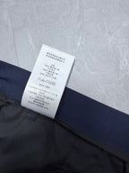 Dior navy shorts leg with overlapping care label and printed instructions
