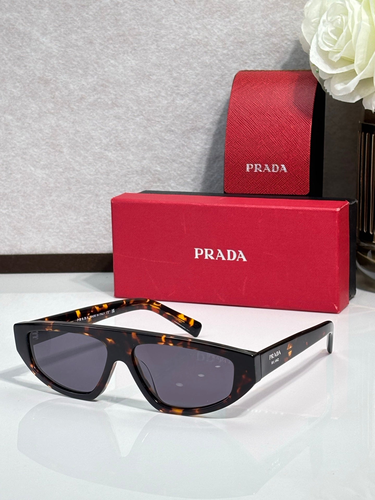 Prada sunglasses with black frames and dark lenses, tortoise temples