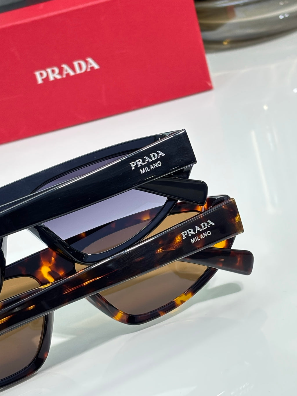 Prada sunglasses with tortoise and black frames, temple text detail