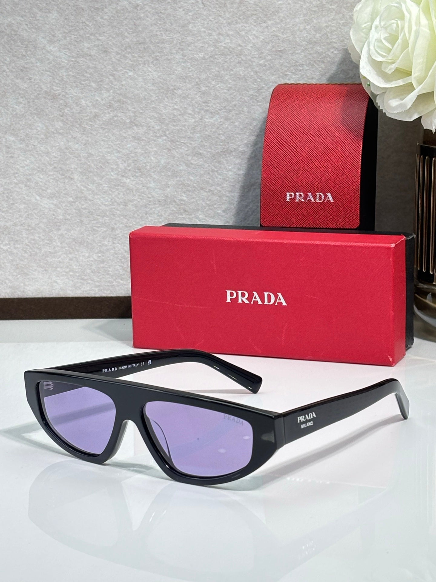 Prada sunglasses with black frames and purple-tinted lenses