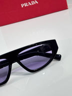 Prada sunglasses with black frame and purple-tinted lens, close-up temple