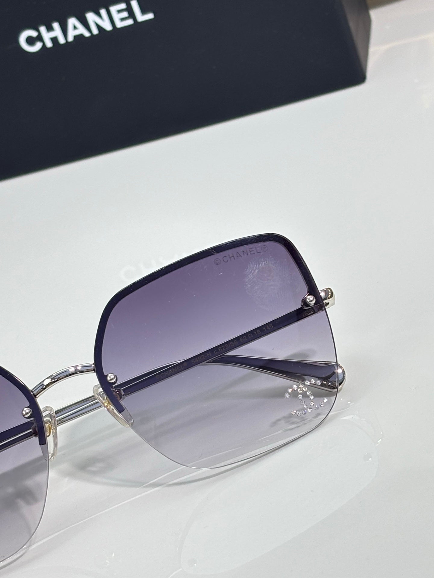 Purple-lens sunglasses with silver-tone frame and side hinge detail