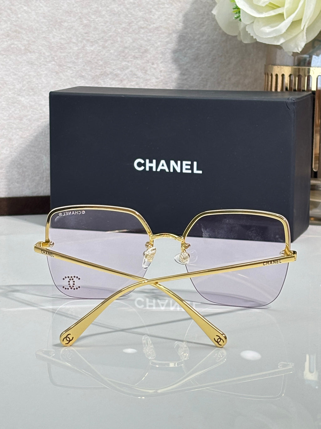 Gold-tone rectangular sunglasses with purple-tinted lenses and metal frame
