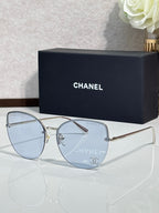 Chanel sunglasses with gold-tone frame and light blue gradient lenses