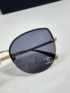 Chanel sunglasses close-up: gold hinges with dark blue gradient lens
