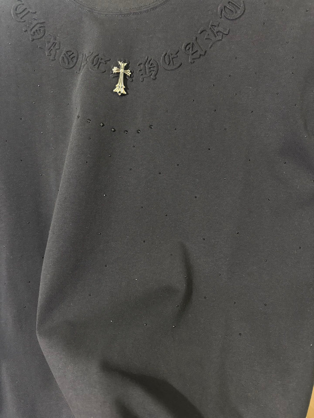 Black T-shirt chest embroidery with gold cross emblem and tiny speckled dots