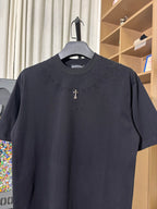 Black crew-neck T-shirt with raised side text and small gold cross emblem