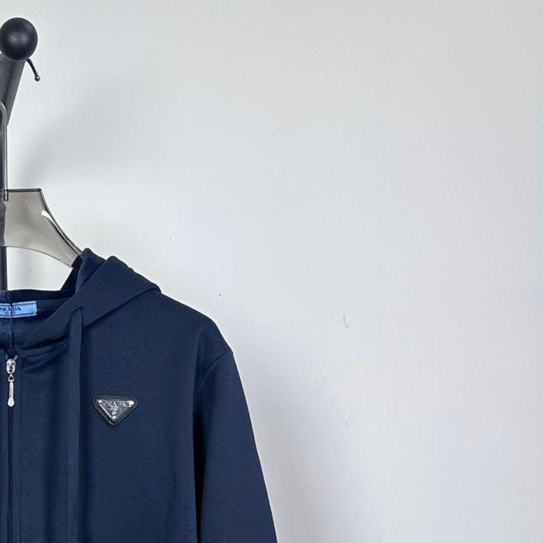 Dark navy zip hoodie with triangle chest logo and zipper pull