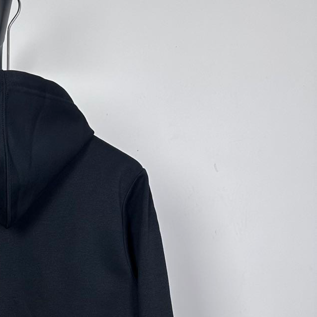 Dark zip-up hoodie side view with smooth sleeve and hood edge