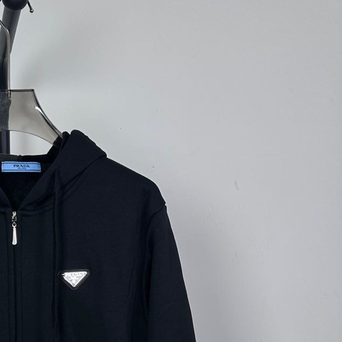 Dark zip-up hoodie chest logo patch detail with front zipper