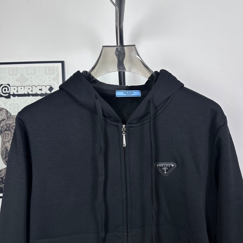 Prada dark zip-up hoodie close-up with front zipper and triangle chest logo patch
