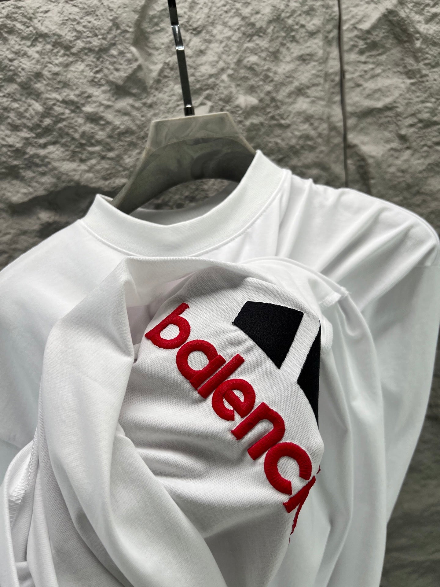 White T-shirt with bold black bars and red text logo graphic