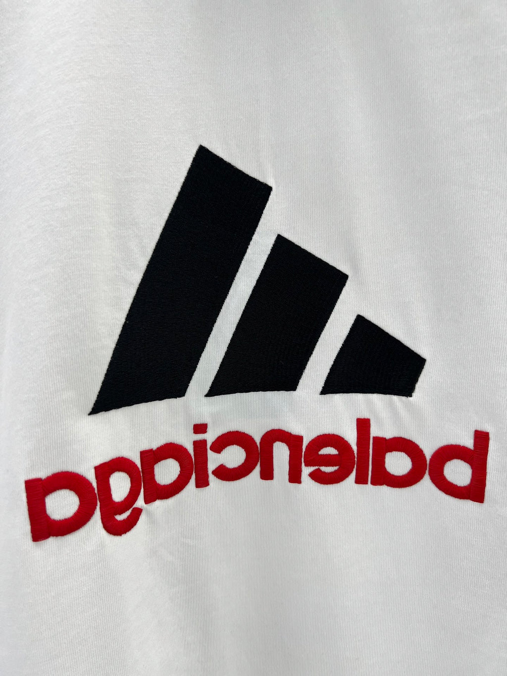 White T-shirt with close-up black stripe logo and red mirrored text