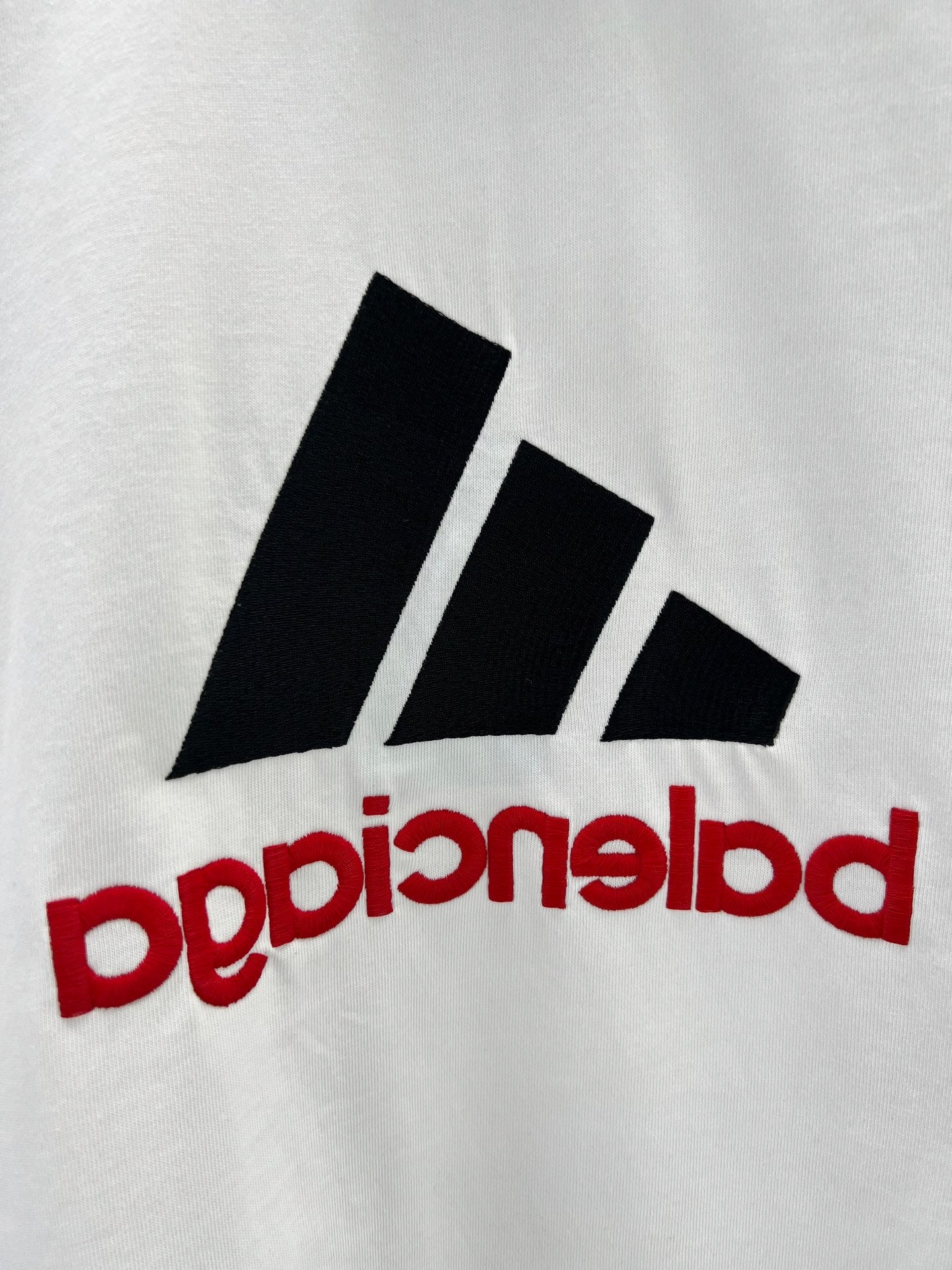 White T-shirt with close-up black stripe logo and red mirrored text