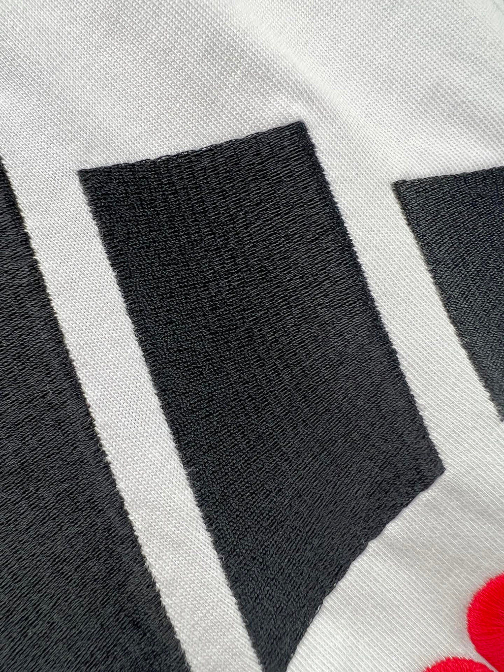 White T-shirt fabric with black stripe logo graphic detail