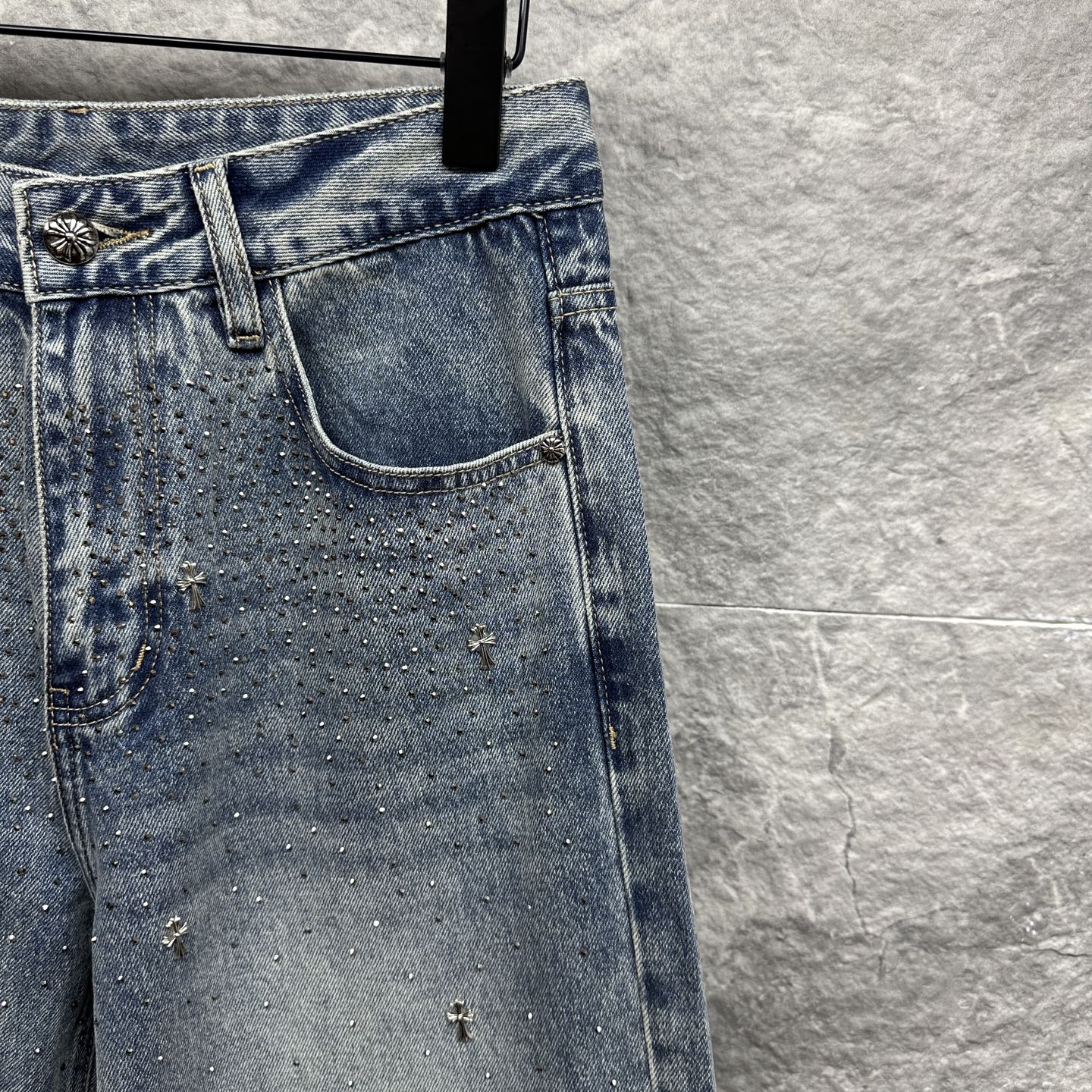 Light blue denim pants with detailed back pocket and scattered star-like embellishments